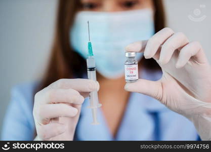 female doctor holding Coronavirus  Covid-19  vaccine bottle and syringe injection medicine