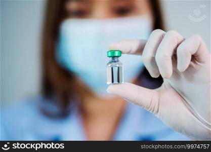 female doctor holding vaccine bottle for injection medicine