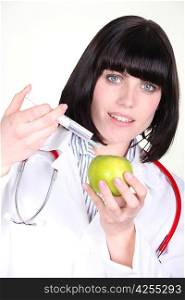 Female doctor injecting apple