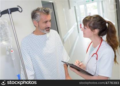 female doctor interacting with patient in hospital corridor