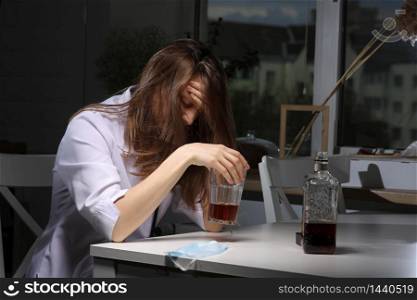 female doctor is depressed. lonely female drinker alcoholic suffer from alcohol addiction having problem, alcoholism concept. the consequences of a pandemic and self-isolation.. female doctor is depressed. lonely female drinker alcoholic suffer from alcohol addiction having problem, alcoholism concept. the consequences of a pandemic and self-isolation