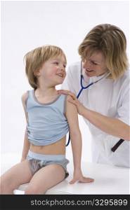 Female doctor is listening to the heart rhythm of a little boy with a stethoscope