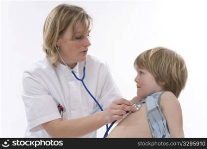 Female doctor is listening to the heart rhythm of a little boy with a stethoscope