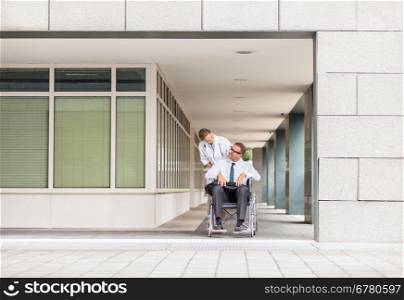 Female doctor is pushing man on wheelchair