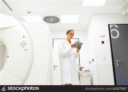 Female doctor looking at digital tablet in treatment room
