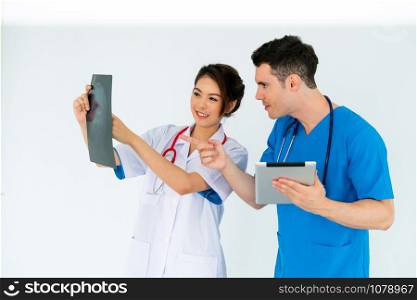 Female doctor looking at x ray film of patient head injury while working with another doctor at the hospital. Medical healthcare staff and doctor service.