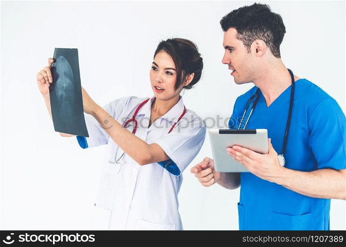 Female doctor looking at x ray film of patient head injury while working with another doctor at the hospital. Medical healthcare staff and doctor service.. Doctors working with x ray film of patient head.
