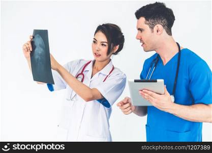 Female doctor looking at x ray film of patient head injury while working with another doctor at the hospital. Medical healthcare staff and doctor service.. Doctors working with x ray film of patient head.