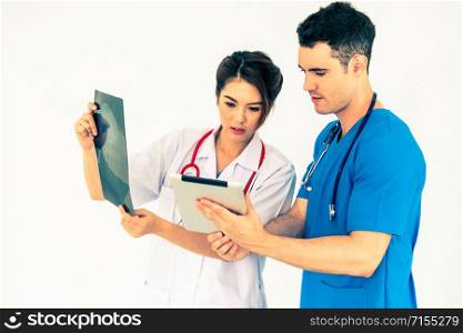 Female doctor looking at x ray film of patient head injury while working with another doctor at the hospital. Medical healthcare staff and doctor service.
