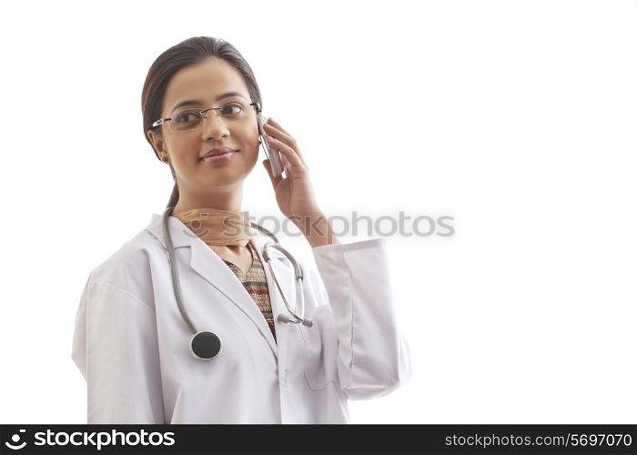 Female doctor looking away while on call against white background