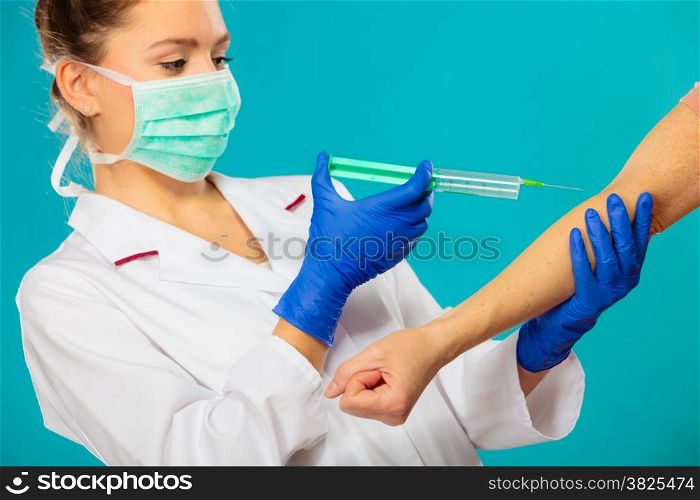 Female doctor or nurse with syringe giving injection to patient. Medical person for health insurance.