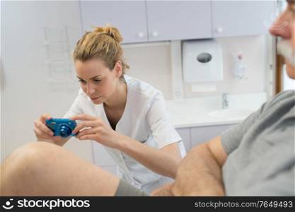female doctor photographing patients leg