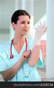 Female doctor putting on rubber glove