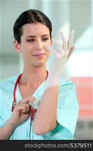 female doctor putting on rubber gloves