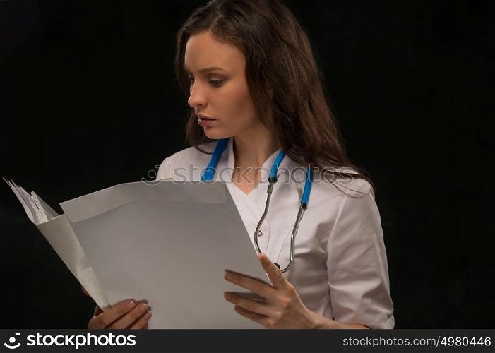 Female doctor reading medical record