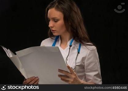 Female doctor reading medical record