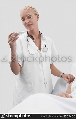 Female doctor reading the temperature of a patient