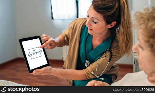 Female doctor showing tablet to female senior patient. Customizable tablet screen. Doctor showing tablet to senior patient