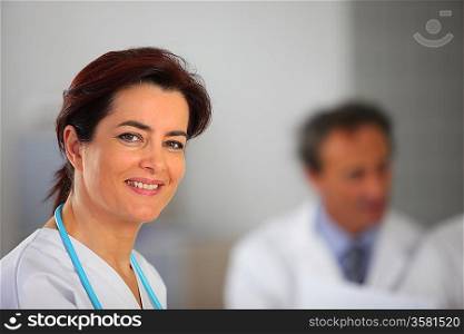 Female doctor stood by colleagues