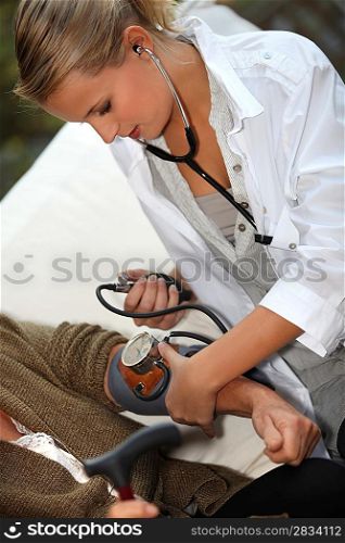 Female doctor taking blood pressure