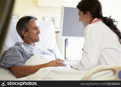 Female Doctor Talking To Male Patient In Hospital Room