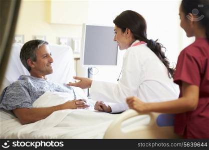 Female Doctor Talking To Male Patient In Hospital Room
