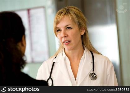Female doctor talking to patient in hospital.