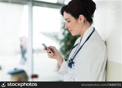 female doctor texting on smartphone in medical office
