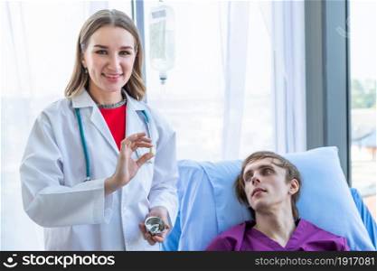 Female doctor therapeutic advising Give Different tablets, pills, medications drugs to a man patient on bed for better healing In the room hospital background.