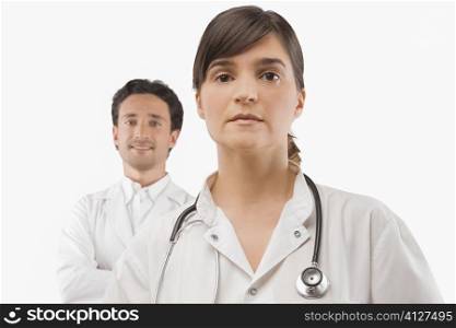 Female doctor thinking with a male doctor smiling behind her