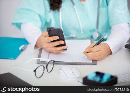 female doctor use a smartphone in her office