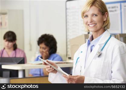Female Doctor Using Digital Tablet At Nurses Station