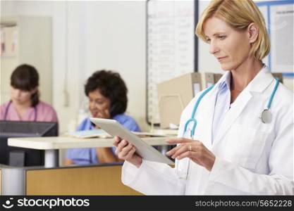 Female Doctor Using Digital Tablet At Nurses Station