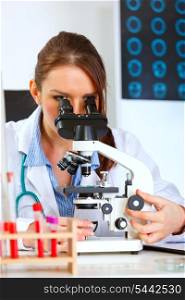 Female doctor using microscope in medical laboratory&#xA;