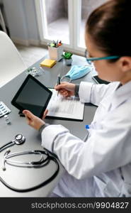 Female doctor using tablet while working in her office