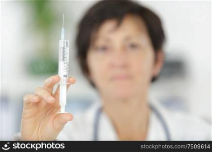 female doctor with stethoscope and syringe