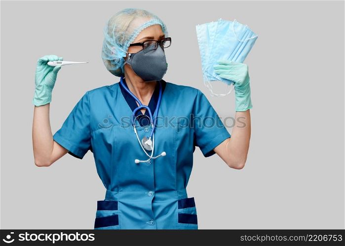 female doctor with stethoscope wearing protective mask and latex gloves over light grey background holding thermometer.. female doctor with stethoscope wearing protective mask and latex gloves over light grey background holding thermometer