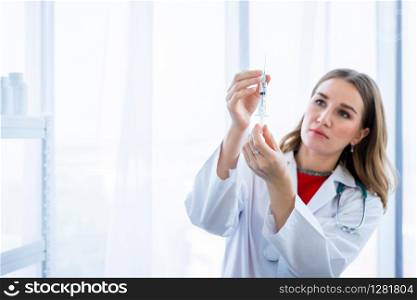 female doctor with stethoscope with holding a syringe in Hospital background