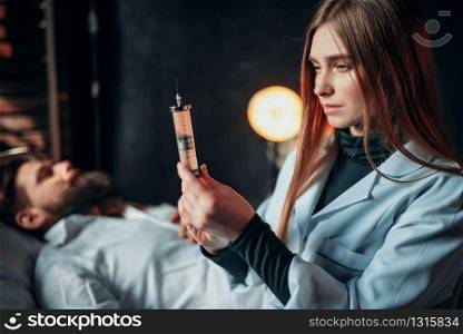 Female doctor with syringe against male patient in hospital bed. Illness of man in clinic, health recovery and treatment. Female doctor with syringe against male patient