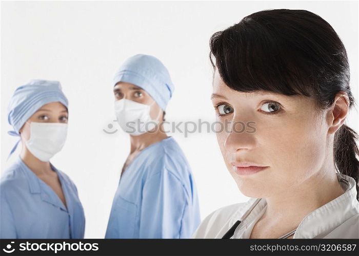 Female doctor with two surgeons in the background