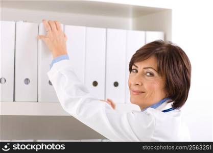 Female doctor working at office, smiling.