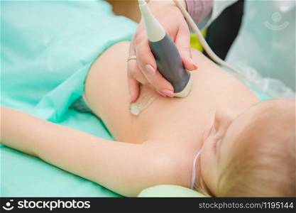 Female doctor working with an ultrasound scanner examining a heart area. Clinical diagnosis of the causes of heart disease in children.. Female doctor working with an ultrasound scanner examining a heart area.