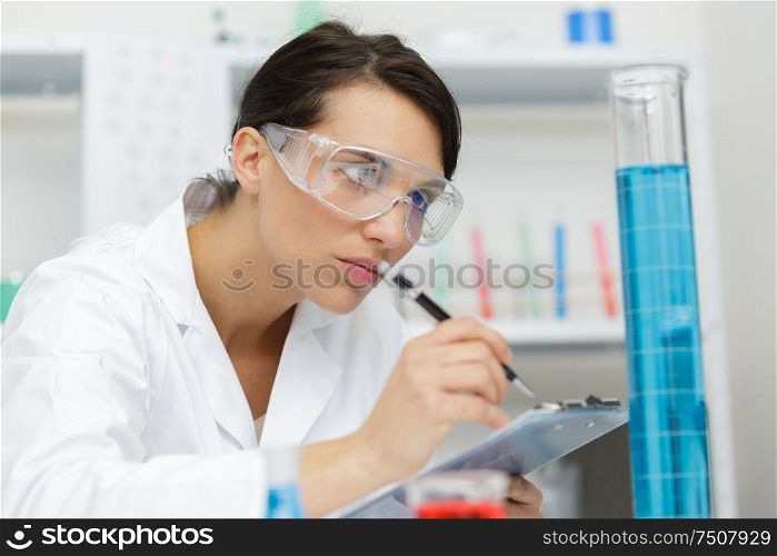 female doctor working with clipboard in lab
