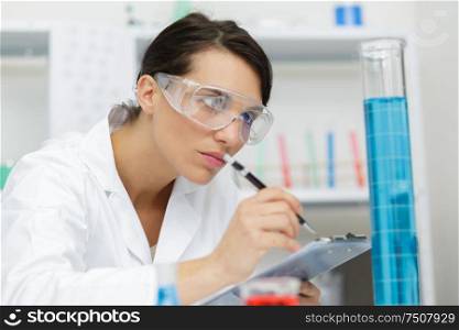 female doctor working with clipboard in lab