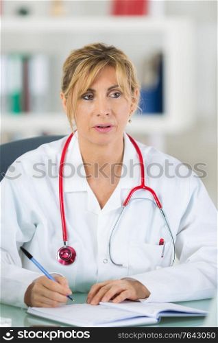 Female doctor writing in notebook
