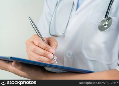 female doctor writing medical information in notebook at hospital