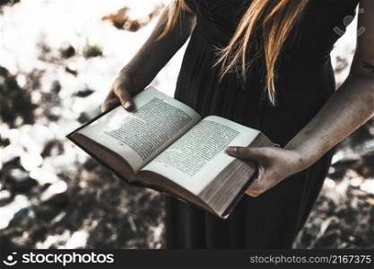 female dress holding opened book woods daytime