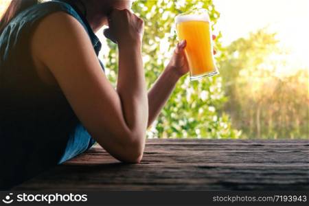 Female Drinking Beer Concept. Woman Relaxing by a Glass of Beer at the Balcony in Summer