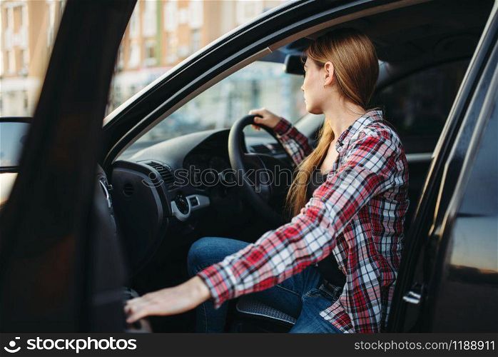 Female driver beginner sitting in a car. Woman in vehicle, driving automobile concept. Female driver beginner sitting in a car