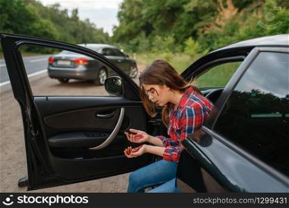 Female driver with broken eyebrow after car accident on road. Automobile crash, blood on the woman&rsquo;s face. Broken automobile or damaged vehicle, auto collision on highway